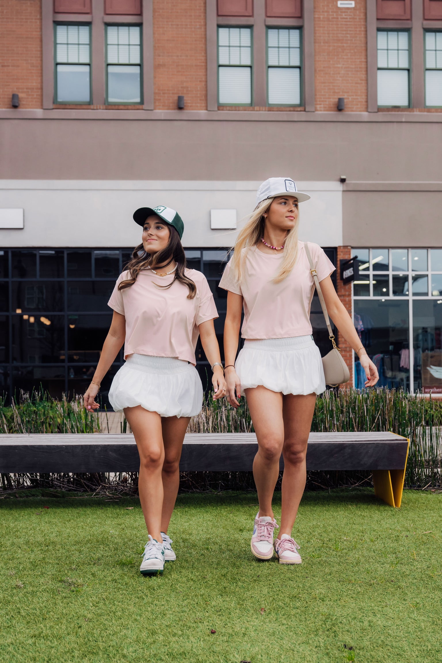two models wearing a pink comfortable t-shirt with white tennis skirts